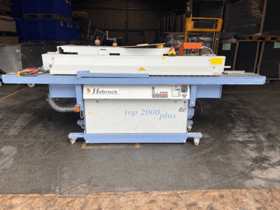 Hebrock Top 2000 Plus, front view; industrial electric machine with control panel, wheels for mobility, and safety labels visible.