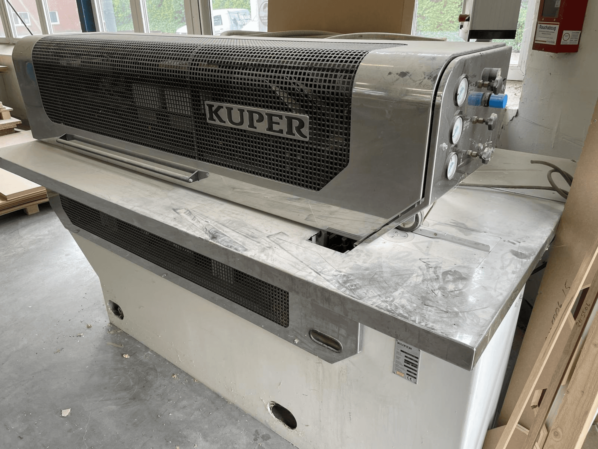 Veneer guillotine KUPER FLI, front view, featuring a stainless steel body, gauges, and a clean cutting area on a workbench.