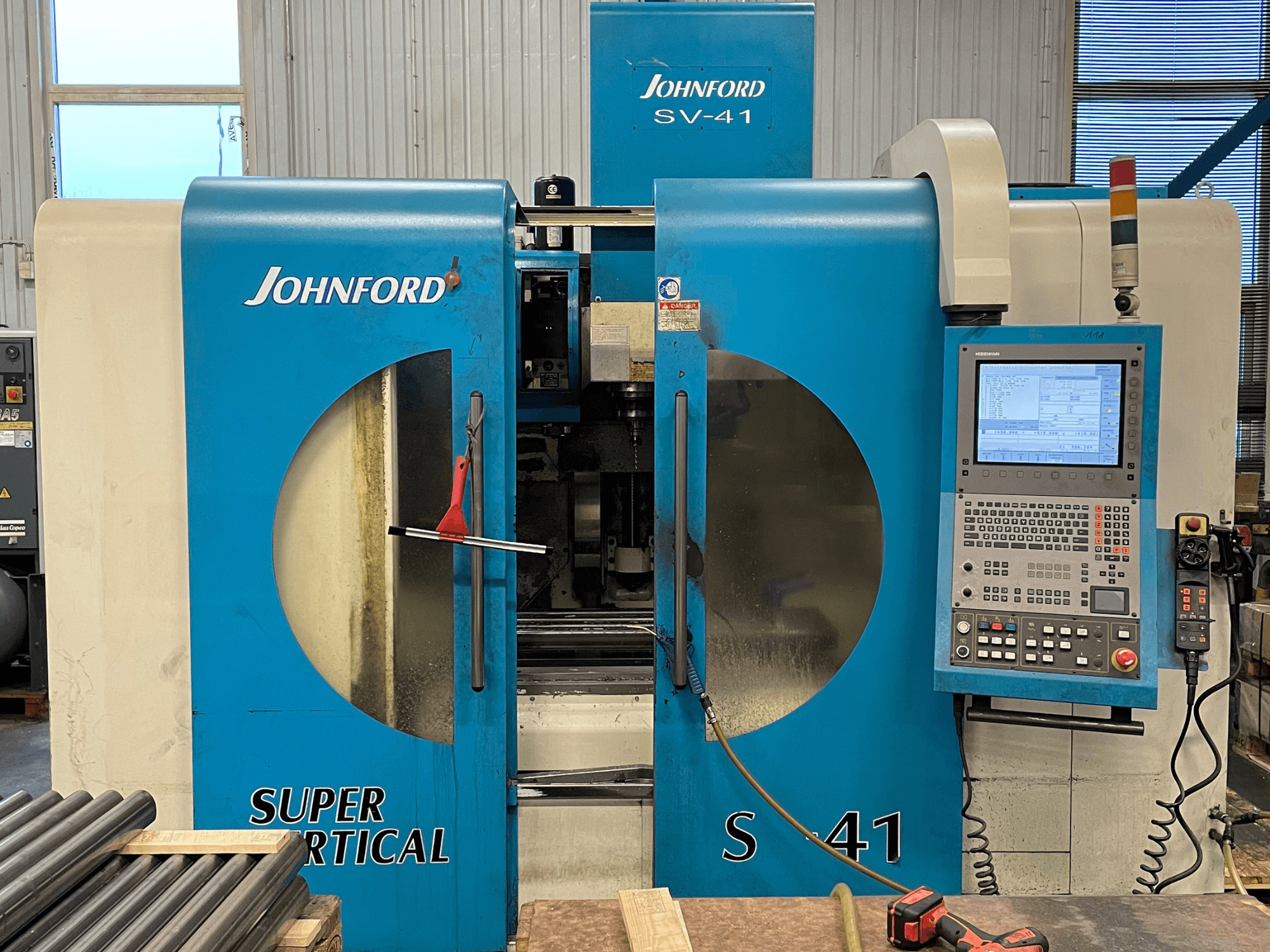 Front view of a Johnford SV-41 vertical machining center, featuring a control panel and clear viewing windows.