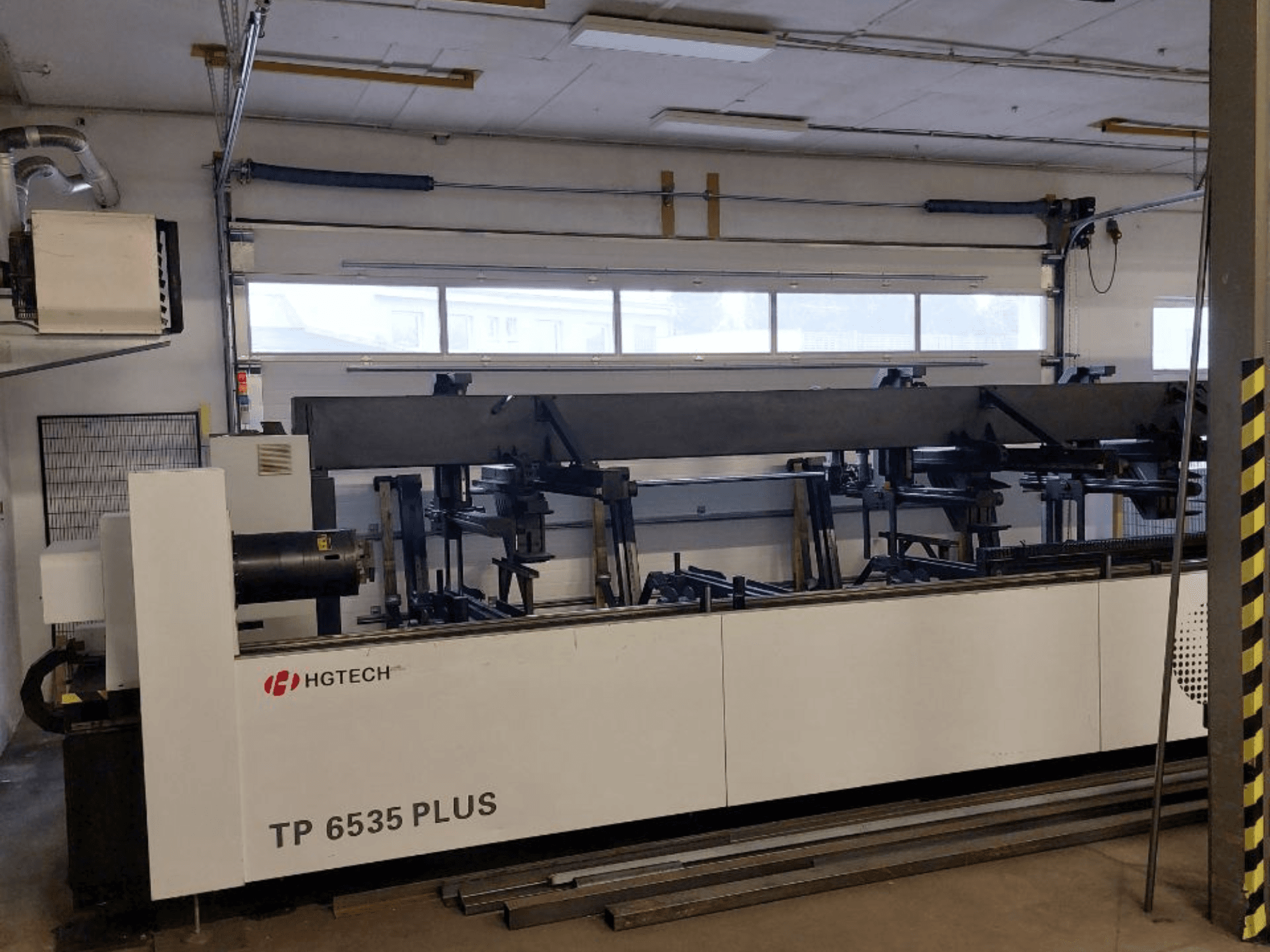 HGTECH TP 6535 PLUS, front view of a large industrial machine with multiple arms for precision fabrication, set in a workshop.