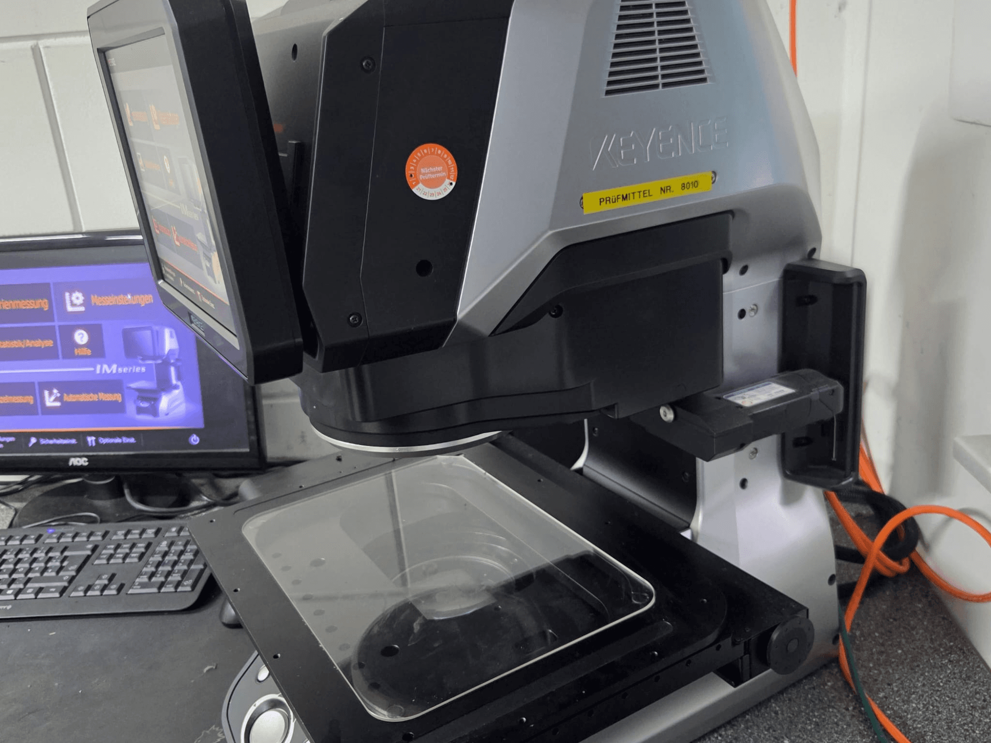 KEYENCE IM 7030 optical measurement machine, front view with touchscreen display and glass measurement plate.