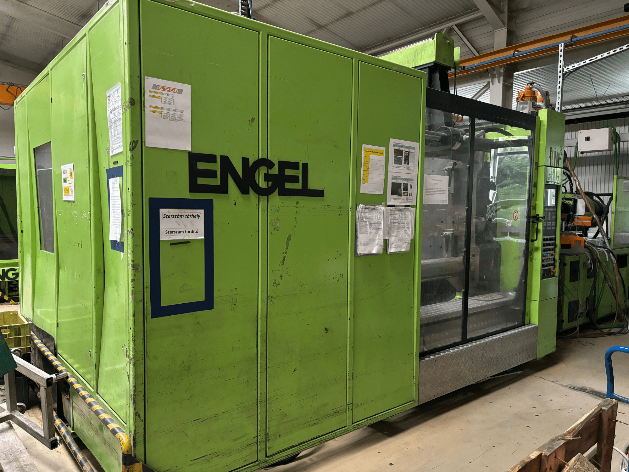Hydraulic injection moulding machine Engel DUO 5550/800, front view, featuring a green exterior and transparent access panel.