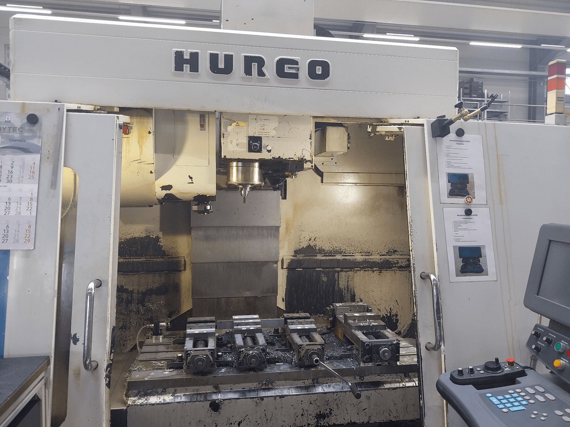 Hurco VMX 42 vertical machining center front view, showing worktable with fixtures and control panel, slightly worn condition.