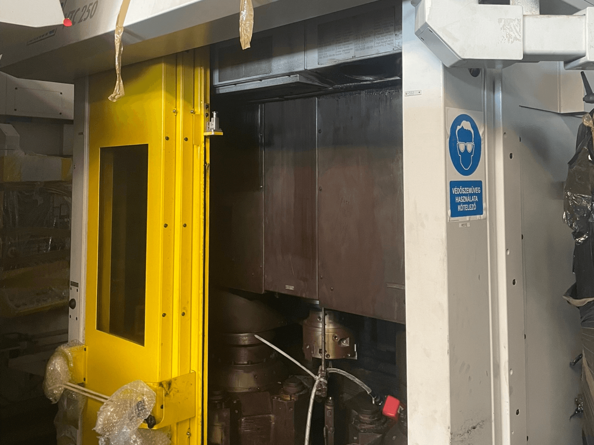 Yellow entrance door of a machine with safety sign, front view of an industrial machine model Z250, showing internal components.